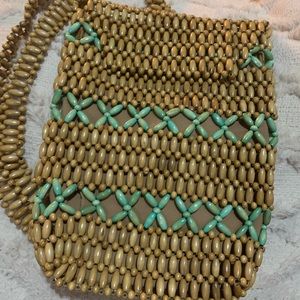 Beaded over the shoulder bag/ backpack style. Clothe lining and zip closure.